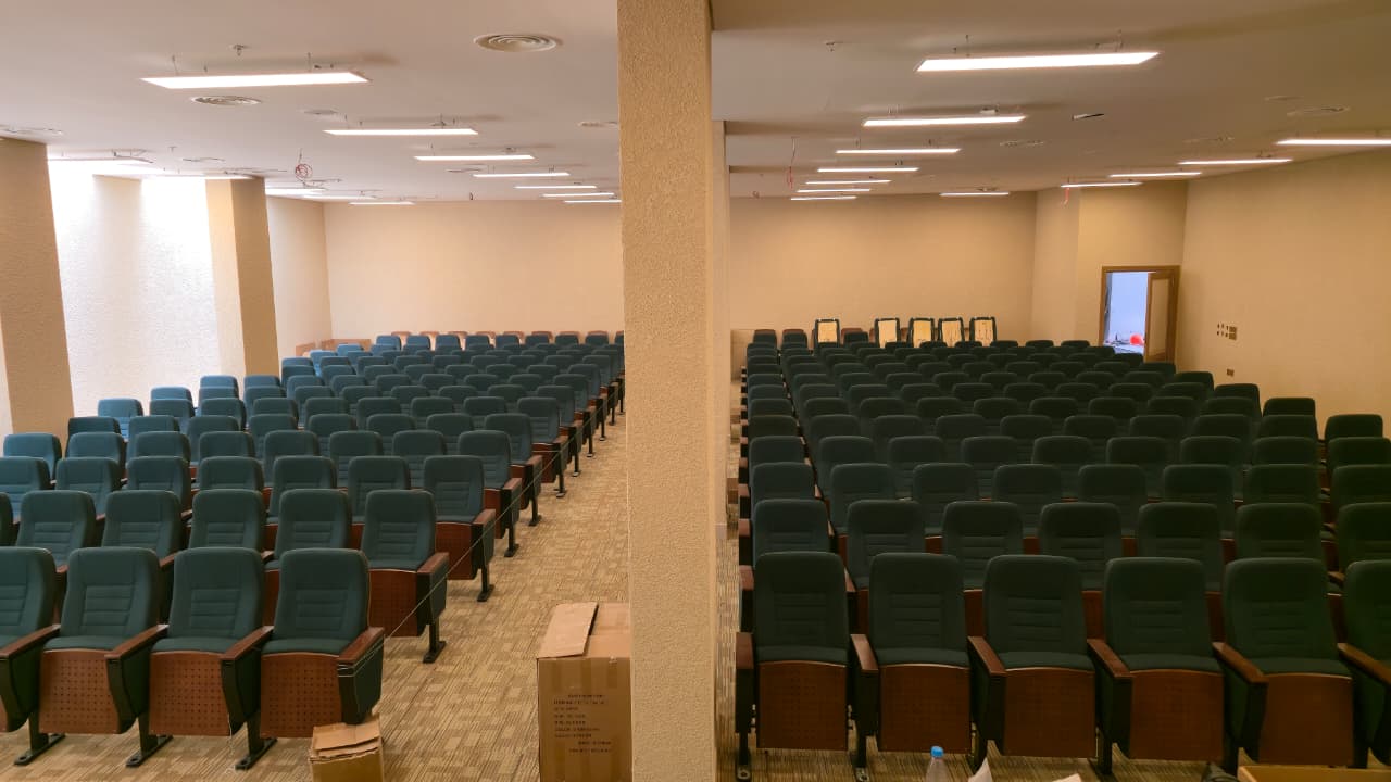 مدرج المحاضرات بعد تركيب الكراسي وأعمال التشطيب والإضاءة